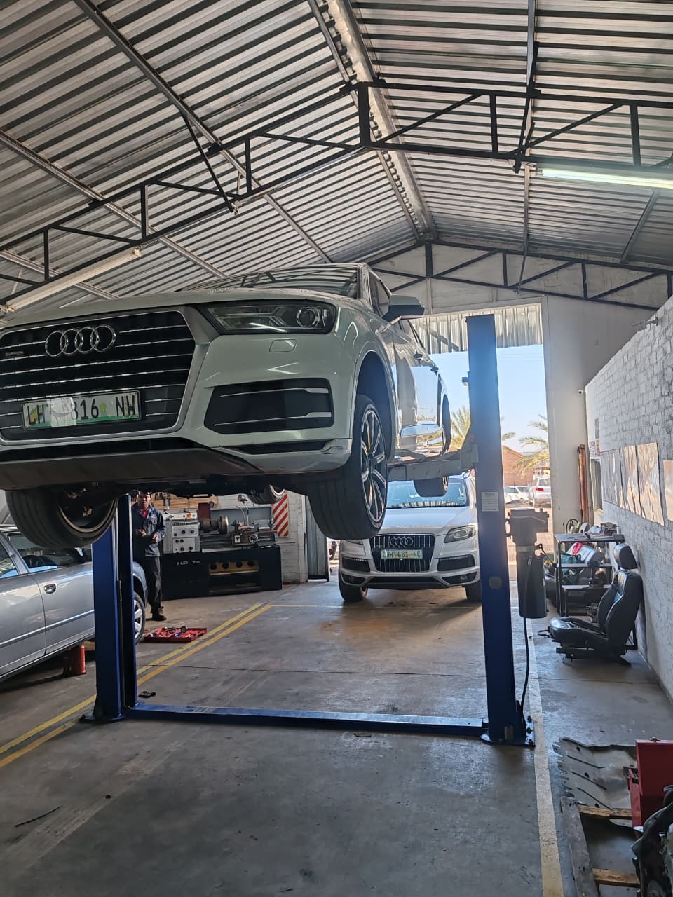 Audi Q7 raised on a two-post lift inside the workshop